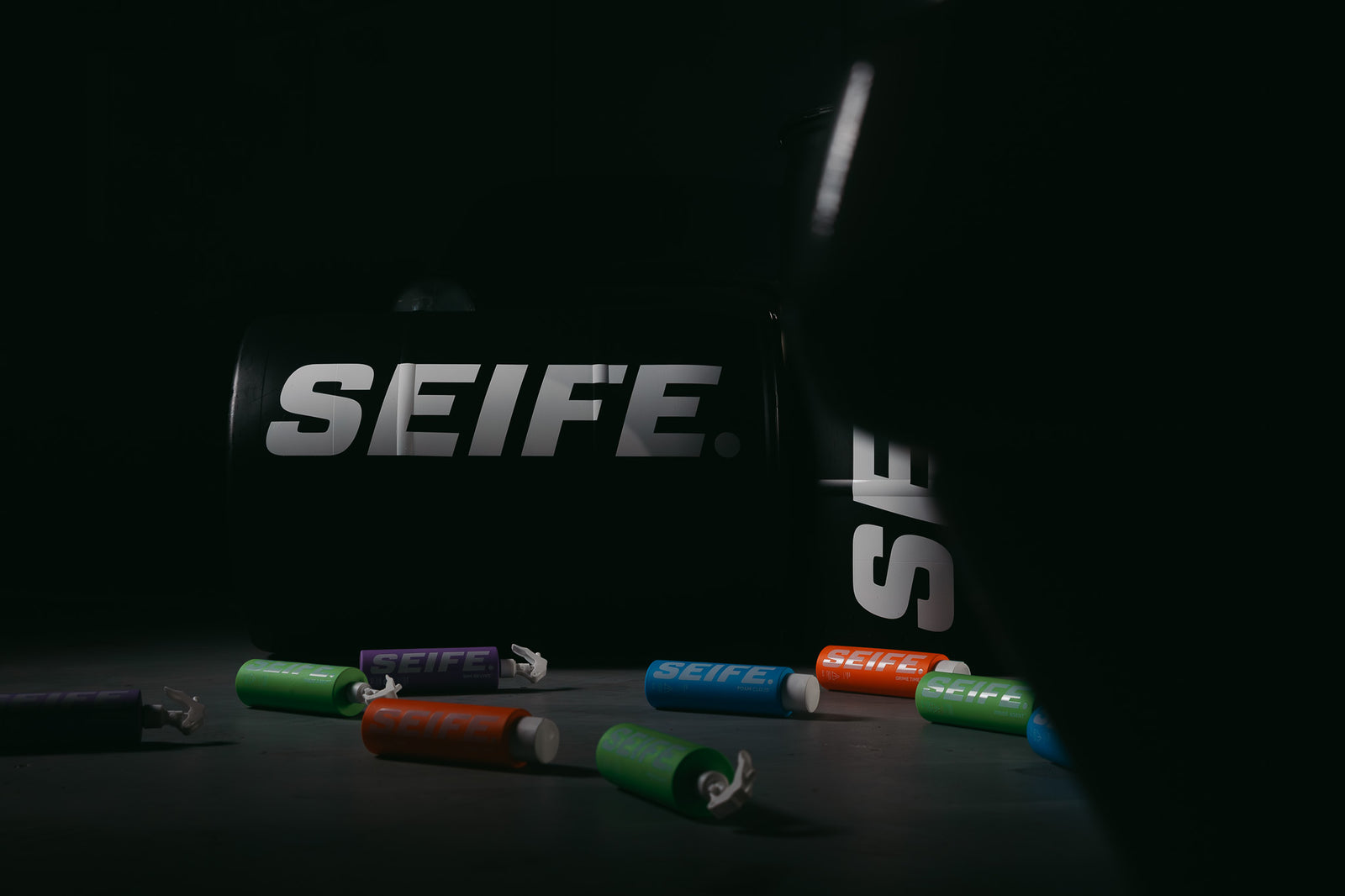 SEIFE branded bag with colour-coded car care bottles on a dark studio floor
