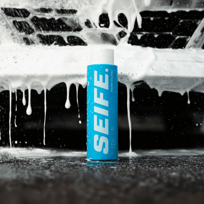 Foam Cloud car wash soap bottle beside thick white foam sheeting off a black car