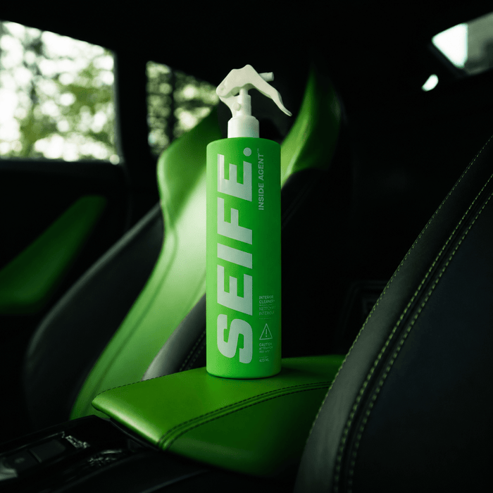 Inside Agent interior cleaner standing on a black leather car seat
