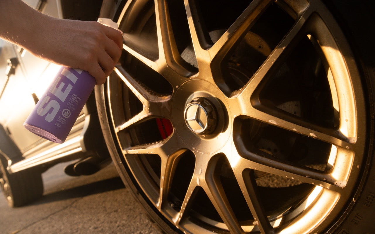Rim Revive wheel cleaner being sprayed onto a gold alloy wheel with a red brake caliper