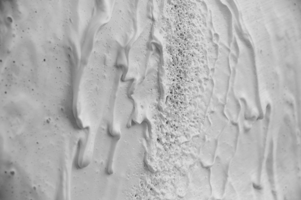 Thick white foam running down a car panel